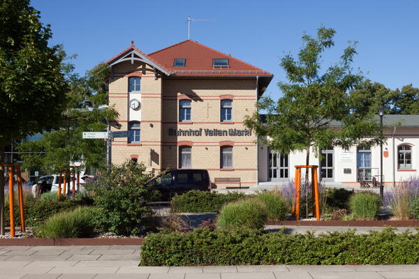 Bild vergrößern: Der Veltener Bahnhof: Ein verklinkertes Gebude mit der Aufschrift "Bahnhof Velten Mark" und einer groen Uhr.